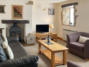 a living room with a couch and a table with a fireplace at Trevena Star in Rosedale Abbey