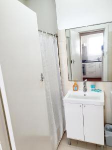 La salle de bains blanche est pourvue d'un lavabo et d'un miroir. dans l'établissement M106 West Perth Studio Apartment near Kings Park, à Perth