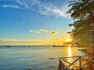 una puesta de sol sobre un cuerpo de agua con un muelle en Tunamaya Beach & Spa Resort Tioman Island, en Tioman Island