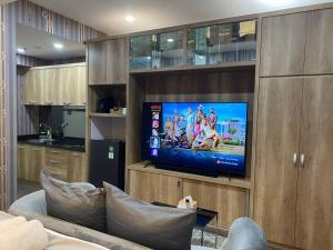 a living room with a flat screen tv on a wall at Savvaya at Tanglin Apartment in Lontar