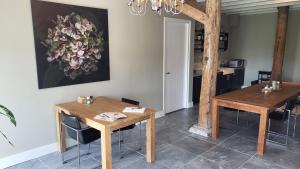 a dining room with two tables and a painting on the wall at The Barnyard in Balinge