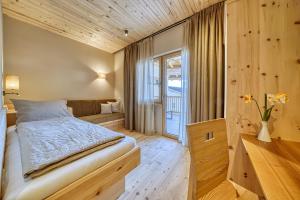 um quarto com uma cama e uma janela em Eco Bnb & Apartments Bründlerhof em Marlengo