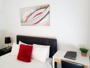 Un dormitorio con una cama con una almohada roja. en M5 West Perth Studio Apartment near Kings Park en Perth