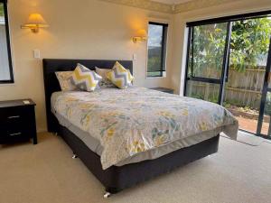 a bedroom with a large bed with pillows on it at Paradise Hideaway in Rotorua