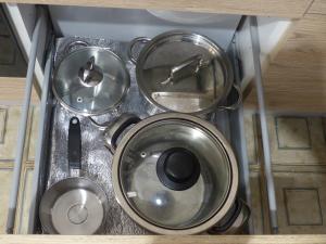 a group of metal pots and pans in a drawer at Villetta Fiorita in San Vito lo Capo