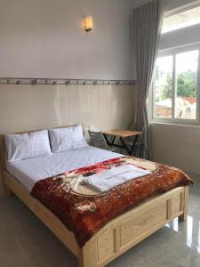 a large bed in a bedroom with a window at Phuong Ngan Guesthouse in Bao Loc