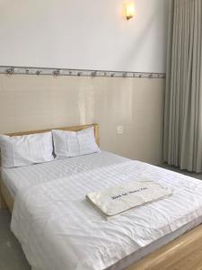 a white bed with a white towel on it at Phuong Ngan Guesthouse in Bao Loc