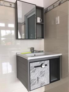 a bathroom with a sink and a mirror at Phuong Ngan Guesthouse in Bao Loc