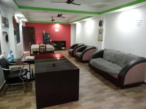 a living room with a couch and a table at Downing Street inn a perfect homestay in Port Blair