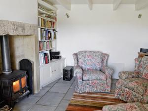 a living room with a chair and a fireplace at Rose Cottage in Rochester