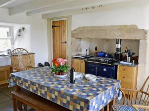 a kitchen with a table with a table cloth on it at Rose Cottage in Rochester