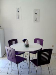 a dining room table with purple chairs and a table at Guest House Petricevic in Split