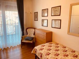 a bedroom with a bed and a dresser and a chair at App4rent Family Apartment 3 camere, 2 bagni, Wi-Fi, animali ammessi in Jesolo