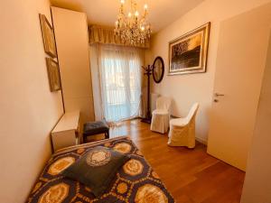 a bedroom with a bed and a chandelier at App4rent Family Apartment 3 camere, 2 bagni, Wi-Fi, animali ammessi in Jesolo