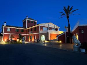 un grand bâtiment avec un palmier en face dans l'établissement Fincahotel Los Naranjos, à Son Sardina