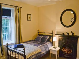 1 dormitorio con cama y espejo en la pared en Court House en Hay-on-Wye