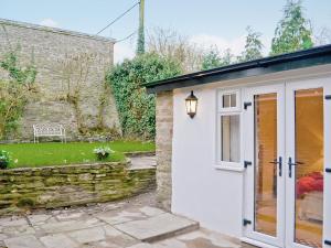 Cottage mit einer weißen Tür und einer Steinmauer in der Unterkunft Court House in Hay-on-Wye
