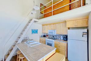 a kitchen with a white refrigerator and wooden cabinets at Lake Chelan Shores The Lake Escape 3 1 in Chelan