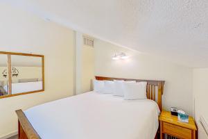 a bedroom with a white bed and a mirror at Lake Chelan Shores The Lake Escape 3 1 in Chelan