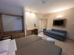 een hotelkamer met een bed en een bank bij Delfino Tuscany Resort in Marina di Cecina