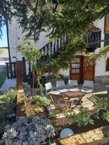 un patio con mesa y sillas bajo un árbol en Chalet nelle vigne, en Novello