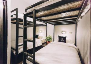 a bedroom with two bunk beds with white sheets at BLOOMZ HOSTEL in Chiang Mai