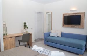 a living room with a blue couch and a tv at Delfino Tuscany Resort in Marina di Cecina