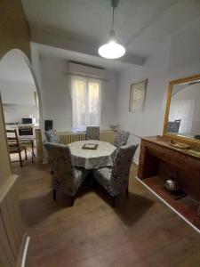 een woonkamer met een tafel en stoelen en een spiegel bij La Maison de Chouquette in Limoux