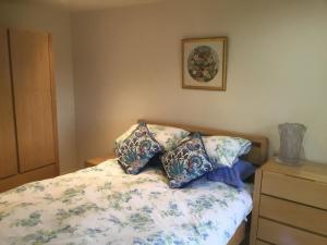a bedroom with a bed with pillows on it at Cute Cottage 2024 Traveller Award in Yateley