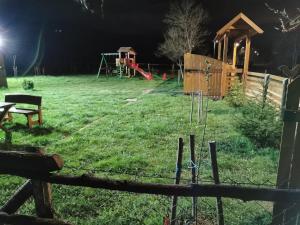 un patio nocturno con parque infantil y estructura de juegos en Wooden House Ripac en Bihać