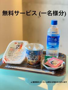 uma bandeja com uma garrafa de água e uma bebida em LUXe em Higashihiroshima