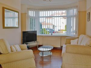 a living room with two couches and a tv at Frankcot in Llandudno