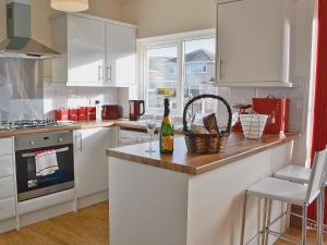 a kitchen with a counter with a bottle of wine at Frankcot in Llandudno
