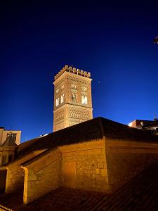 une tour d'horloge au sommet d'un bâtiment la nuit dans l'établissement Torre Mudéjar, à Teruel