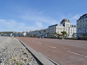 a city street with white buildings and a road at Frankcot in Llandudno