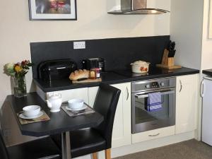 a kitchen with a black counter top and a table at Master Mustard in Hartoft End