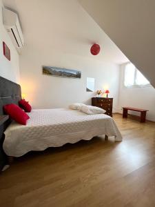 - une chambre avec un lit doté de draps blancs et d'oreillers rouges dans l'établissement Le Quindio, à Bras-Panon