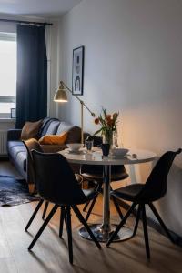 een woonkamer met een tafel en stoelen en een bank bij Studio King'sRoad in Kuopio