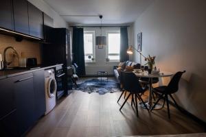 a kitchen and a living room with a table and chairs at Studio King'sRoad in Kuopio +8 photos