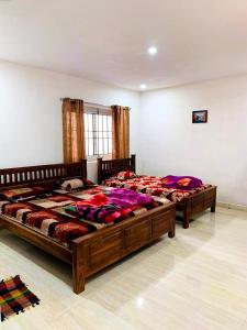 two large beds in a room with at Kalyani Homestay in Kodaikānāl