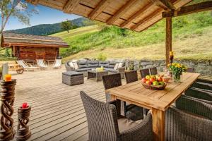 a wooden deck with a table and chairs at Chalet OVO La Vieille Ferme - OVO Network in Manigod