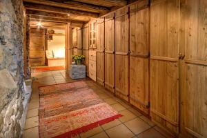 a hallway with wood paneled walls and a tile floor at Chalet OVO La Vieille Ferme - OVO Network in Manigod