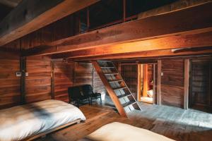 Pokój na poddaszu z łóżkiem piętrowym i drabiną w obiekcie 古民家オーベルジュmocca w mieście Kokuryō
