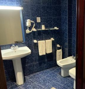 bagno con lavandino, servizi igienici e specchio di Hotel Folch a Sant Julià de Lòria
