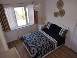 a bedroom with a black and white bed and a window at 33 Valentia place in Newcastle