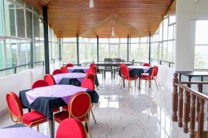 a dining room with tables and red chairs at Span Grand @ Nuwara Eliya in Nuwara Eliya