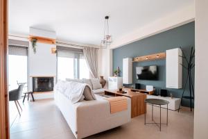 uma sala de estar com um sofá branco e uma televisão em Villa Athina em Preveza