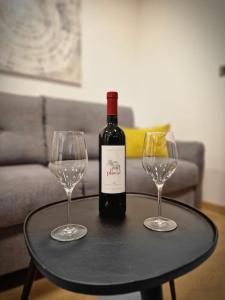 una botella de vino y dos copas de vino en una mesa en G-in-St, en Split