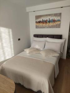 1 dormitorio con 1 cama blanca grande con almohadas blancas en G-in-St en Split