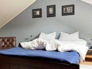 a bed with a blue blanket and two pillows at Holiday home Austefjorden in Austefjorden